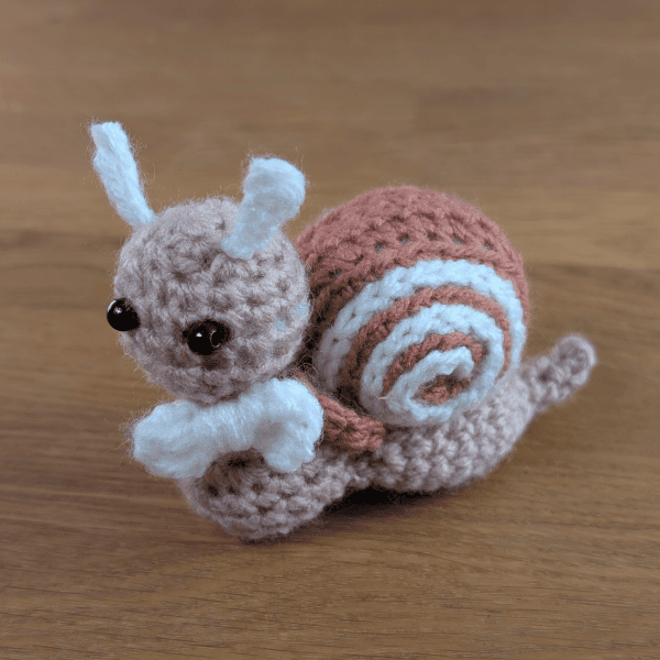 Handgehäkelte Schnecke in Rosa und Weiß – 10 × 12 cm
