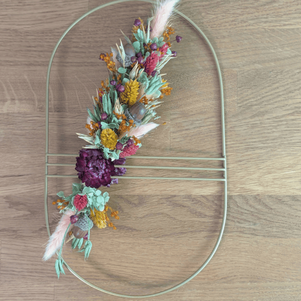 Trockenblumenschmuck auf goldenem Ovalornament – 17,5 × 30 cm